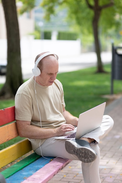 mężczyzna pracuje na laptopie w parku