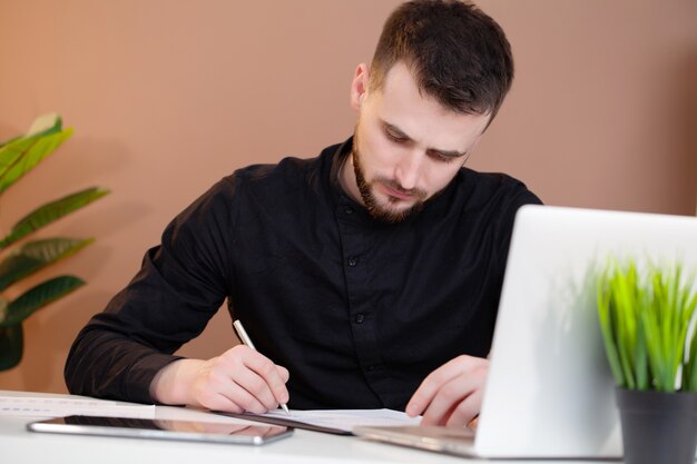 Mężczyzna pracuje przy biurem na laptopie