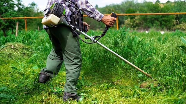 Mężczyzna pracuje z ręczną kosiarką w ogrodzie