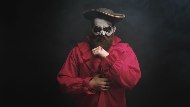 Mężczyzna Przebrany Za Strasznego Pirata W Czerwonej Koszuli I Kapeluszu Na Halloween Na Czarnym Tle.