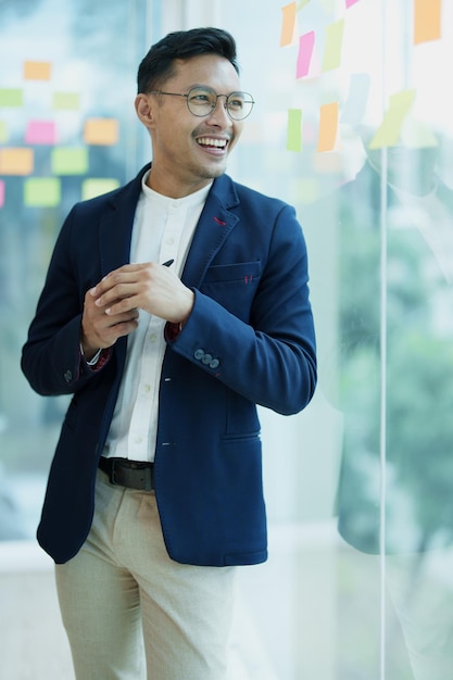 Mężczyzna przedsiębiorca właściciel firmy lub azjatycki mężczyzna biznesmen stojący na spotkaniu z uśmiechniętymi twarzami z pracy