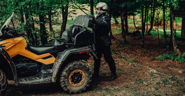 Mężczyzna przygotowuje quada do ekstremalnej jazdy w lesie