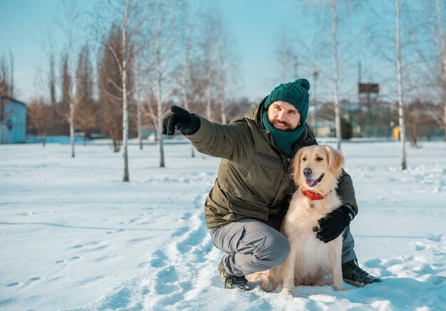 Zdjęcie mężczyzna przytula się z psem golden retriever na zewnątrz