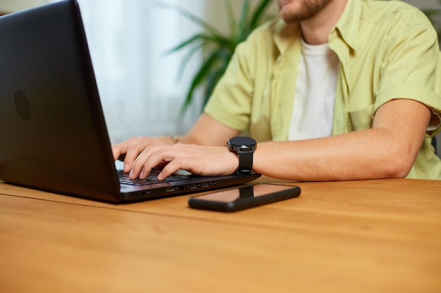 Mężczyzna ręce pisząc coś na laptopie pracującym na komputerze