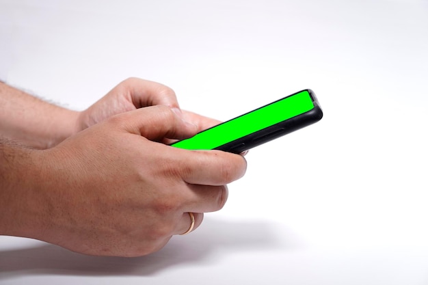 Mężczyzna ręce trzymając inteligentny telefon z zielonym ekranem do projektowania