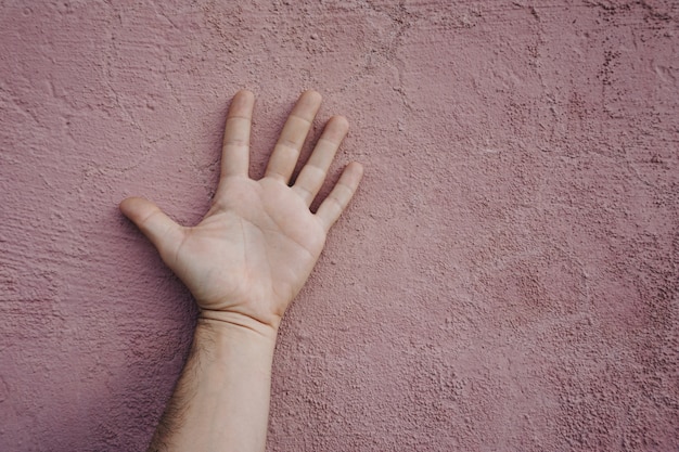 mężczyzna ręką wskazując na różowej ścianie