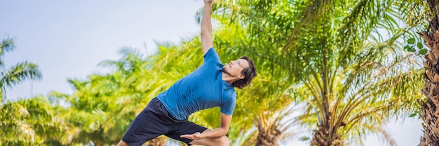 Mężczyzna robi jogę w długim formacie transparentu tropikalnego parku