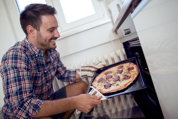 Mężczyzna robi pizzy w domu