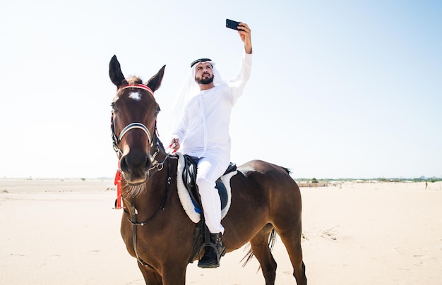 Zdjęcie mężczyzna robi selfie na koniu podczas deserów.