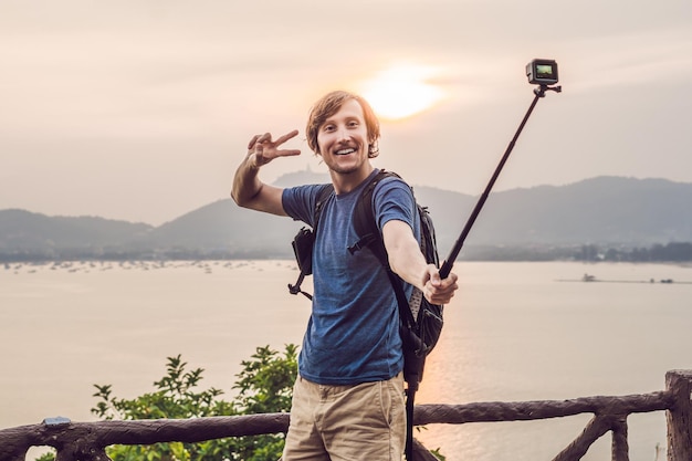 Mężczyzna robi selfie na tle zachodu słońca