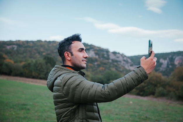 Mężczyzna robi selfie na zewnątrz w polu jesienią