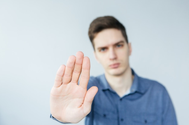 Zdjęcie mężczyzna robi sygnałowi stop. człowiek z wyciągniętym ramieniem. młody człowiek mówi nie