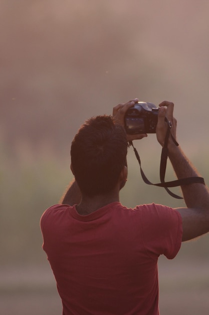 Mężczyzna robiący zdjęcie aparatem dslr.