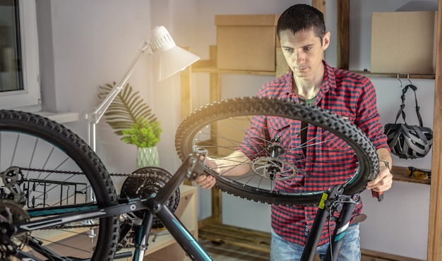 Mężczyzna rozkłada rower górski do konserwacji. Koncepcja mocowania i przygotowania roweru do nowego sezonu