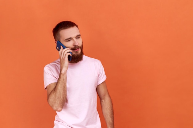 Mężczyzna rozmawia przez telefon, aby omówić plany przystępnych taryf roamingowych