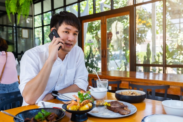 Mężczyzna rozmawia przez telefon komórkowy w restauracji