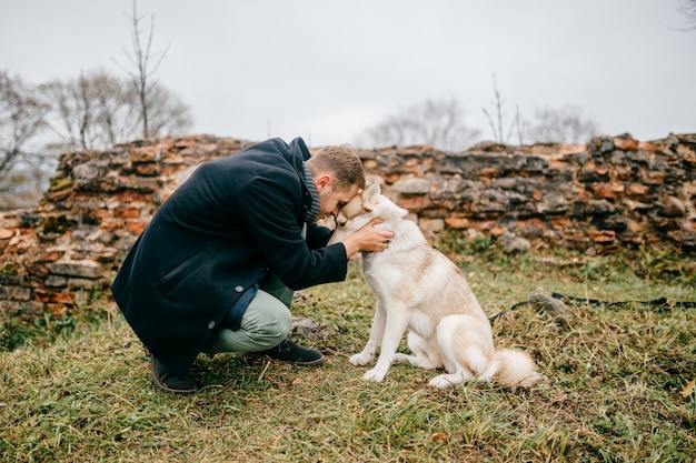 Zdjęcie mężczyzna ściska husky plenerowego.