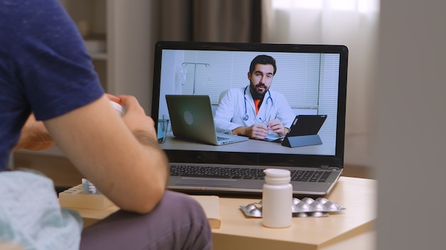 Mężczyzna Siedzący Na Kanapie Na Internetowej Konsultacji Lekarskiej Podczas Blokady Ciążowej