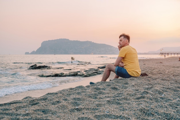 Mężczyzna Siedzi Na Plaży I Patrzy Na Morze W Mieście Alanya Indyk Podróżujący Lub Koncepcja Wakacji