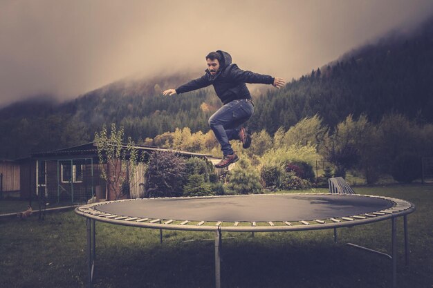 Zdjęcie mężczyzna skaczący z trampoliny na niebo