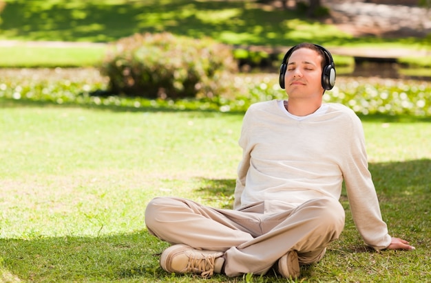 Mężczyzna słucha muzyka w parku