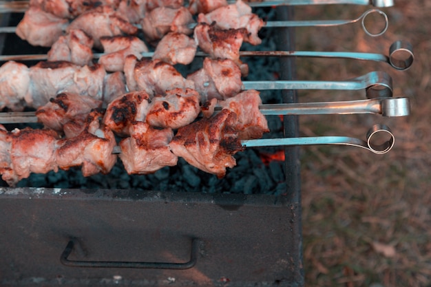 Mężczyzna smaży shish kebab na grillu. Zbliżenie dłoni na zewnątrz