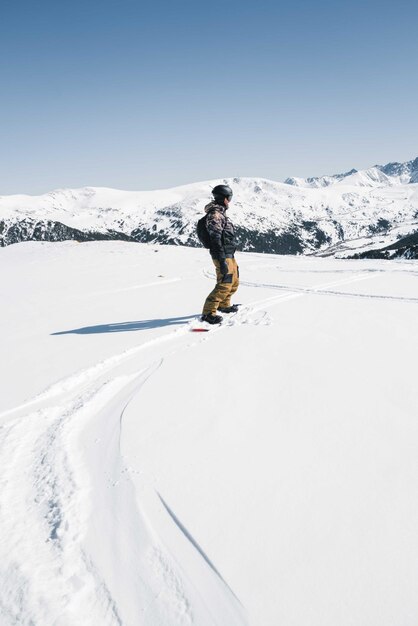 Mężczyzna snowboarding off piste zboczu