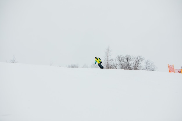 Mężczyzna snowboardzista na stoku narciarskim kopiuje przestrzeń sportów zimowych