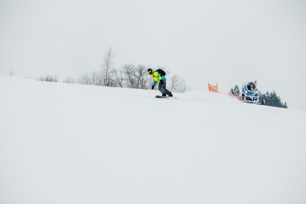 Mężczyzna snowboardzista na stoku narciarskim kopiuje przestrzeń sportów zimowych