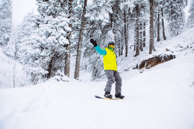 Mężczyzna snowboardzista w zimowym lesie kopia przestrzeń