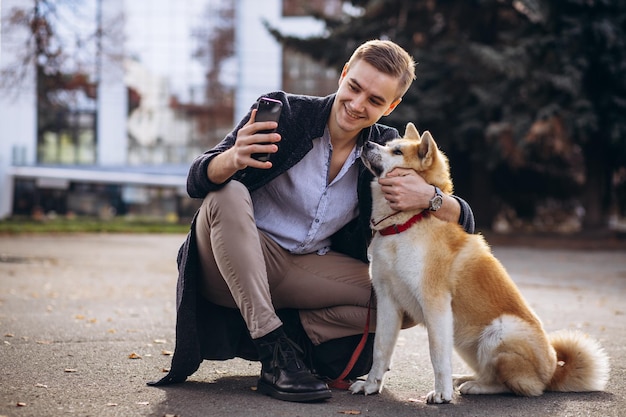 Mężczyzna spacerujący z psem i rozmawiający przez telefon