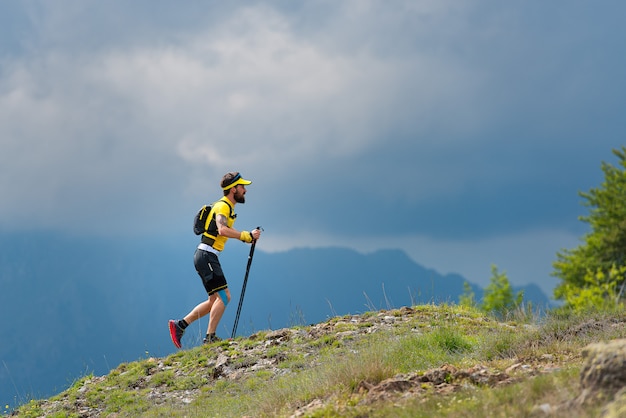 Mężczyzna sportowiec wspina się na zboczu góry podczas szkolenia maraton górski