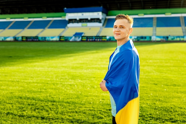 Mężczyzna stoi na polu z flagą z napisem Ukraina.