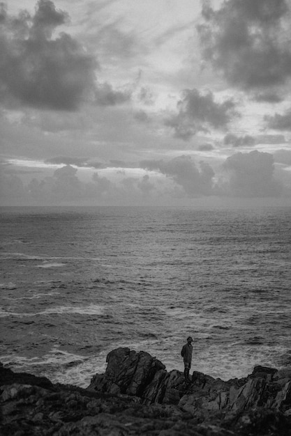 Mężczyzna stojący na skałach przy plaży?