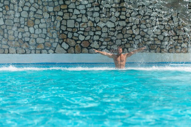 Mężczyzna stojący pod wodą w publicznym basenie