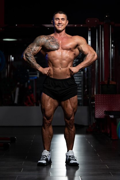 Mężczyzna Stojący Silny Na Siłowni I Napinanie Mięśni Mięśni Atletyczny Kulturysta Model Fitness Pozuje Po Ćwiczeniach