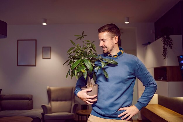 Mężczyzna stojący w domu z rośliną doniczkową