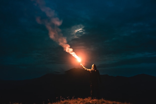 Mężczyzna stojący z kijem fajerwerków na górze