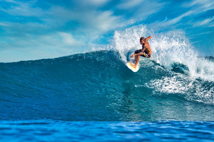 Zdjęcie mężczyzna surfer na niebieskiej fali w słoneczny dzień