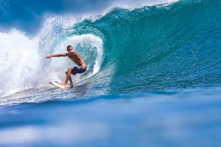Zdjęcie mężczyzna surfer na niebieskiej fali w słoneczny dzień