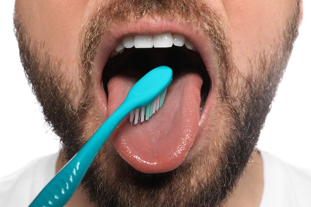 Mężczyzna szczotkuje jego język na białym tła zbliżeniu Opieka stomatologiczna