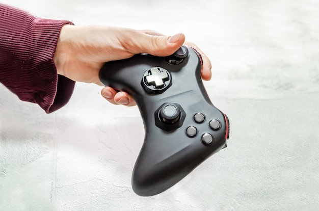 Mężczyzna trzyma bezprzewodowy kontroler gier w ręcznym gamepadzie do gier wideo Ręka demonstruje gamepada