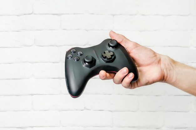 Mężczyzna trzyma bezprzewodowy kontroler gier w ręcznym gamepadzie do gier wideo Ręka demonstruje gamepada