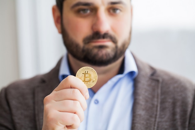 Mężczyzna trzyma bitcoiny w swoim biurze
