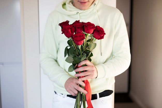 Zdjęcie mężczyzna trzyma bukiet czerwonych róż na walentynki