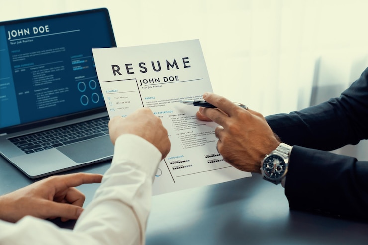 Zdjęcie mężczyzna trzyma cv przed laptopem