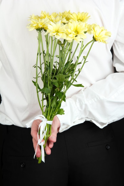 Mężczyzna trzyma kwiaty z bliska