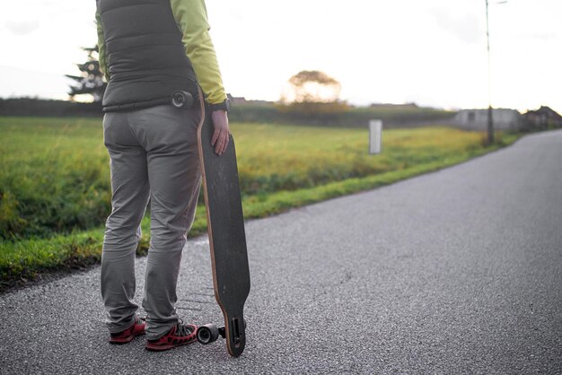 Mężczyzna trzyma longboard i przygotowuje się do jazdy