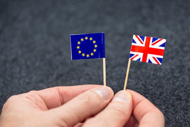 Mężczyzna Trzyma Małe Papierowe Flaga Ue I Wielka Brytania Jako Symbol Brexit, Pojęcie Obrazek