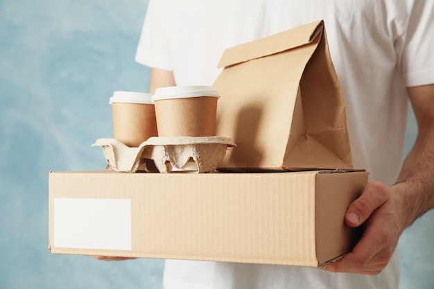 Zdjęcie mężczyzna trzyma puste pudełko, filiżanki kawy i pakiet papieru kryty, miejsca na tekst
